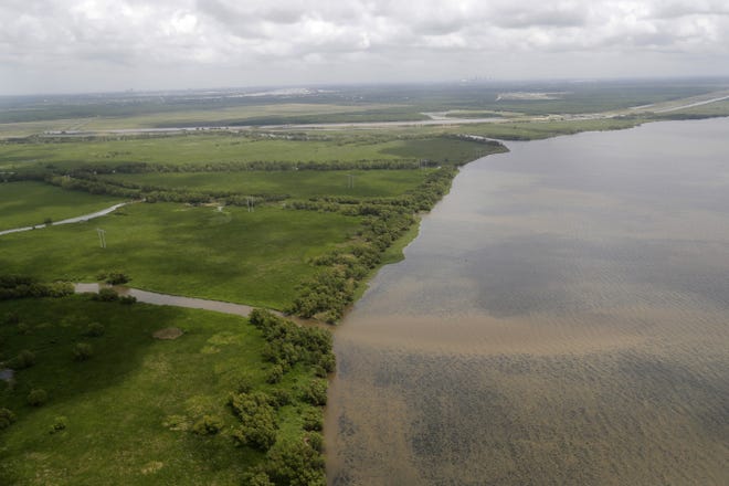 The Davis Pond Diversion empties into Lake Cataouache on May 1, with tree growth on the edges of the channels in St. Charles Parish. Engineers hope to remake some eroded marshes by siphoning off sediment-rich water rom the Mississippi River that can be channeled into coastal wetlabnds. [AP Photo/Gerald Herbert]