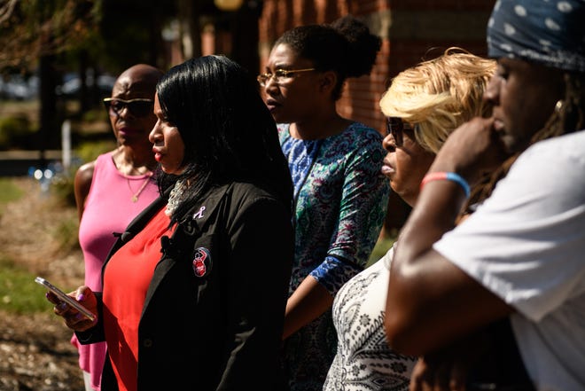 Kathy Greggs, of the Fayetteville Police Accountability Community Task, talks to the media with Reshod Everett's family members standing behind her on Thursday, Oct. 3, 2019. [Andrew Craft/The Fayetteville Observer]