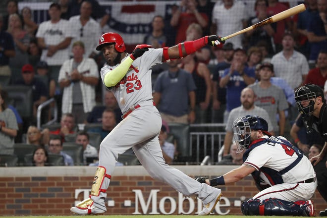 St. Louis' Marcell Ozuna hits a two-run double off Atlanta's Mark Melancon in the ninth inning while the Braves' Francisco Cervelli watches during Game 1 of the NLDS on Thursday. [John Bazemore/The Associated Press]