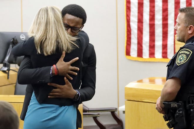 Botham Jean's younger brother Brandt Jean hugs convicted murderer and former Dallas police officer Amber Guyger after delivering his impact statement to her after she was sentenced to 10 years in jail, Wednesday, Oct. 2, 2019, in Dallas. Guyger shot and killed Botham Jean, an unarmed 26-year-old neighbor in his own apartment last year. She told police she thought his apartment was her own and that he was an intruder. [TOM FOX/DALLAS MORNING NEWS VIA AP/POOL]