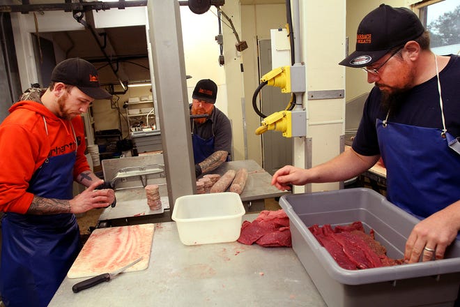 Frank Molitor, left, Kenney Schrock and Devan Youtzy prepare and cut meat on Wednesday, Oct. 2, 2019, at Harbach Meats near Freeport. [JANE LETHLEAN/THE JOURNAL-STANDARD CORRESPONDENT]