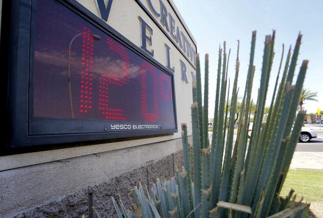 A sign in direct sunlight indicates 120 degrees in Phoenix. A proposed law would require carmakers to build alarms for backseats is being pushed by child advocates who say it will prevent kids from dying in hot cars. [AP Photo/Matt York, File]