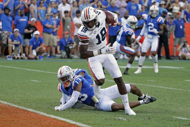 Auburn wide receiver Seth Williams (18) runs to the end zone past Florida defensive back Donovan Stiner (13) for a touchdown on a 32-yard pass play during the first half of an NCAA college football game, Saturday, Oct. 5, 2019, in Gainesville, Fla. (AP Photo/John Raoux)
