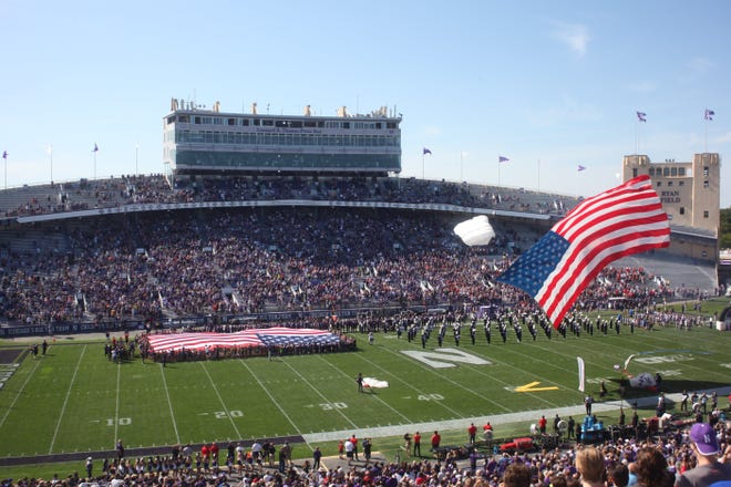 A parachuter flies in with an American flag during pregame ceremonies earlier this season at Northwestern's Ryan Field. [Steve Stephens/Dispatch]
