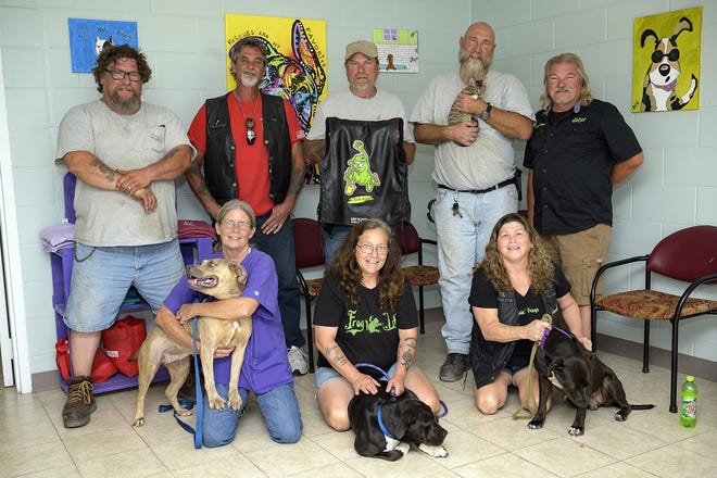 Members of the Pissin' Frogs motorcycle group pose with some pets waiting to be adopted at the Humane Society of Lake County in Umatilla. [Cindy Sharp/Correspondent]