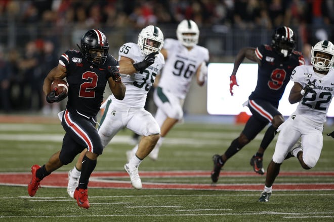 Ohio State running back J.K. Dobbins, left, outruns the Michigan State defense to score a touchdown during the first half of an NCAA college football game Saturday, Oct. 5, 2019, in Columbus, Ohio. (AP Photo/Jay LaPrete)