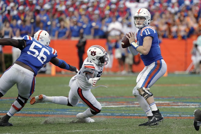 Florida quarterback Kyle Trask (11) looks for a receiver as Auburn defensive end T.D. Moultry tries to stop him during the second half Saturday in Gainesville. [JOHN RAOUX/THE ASSOCIATED PRESS]