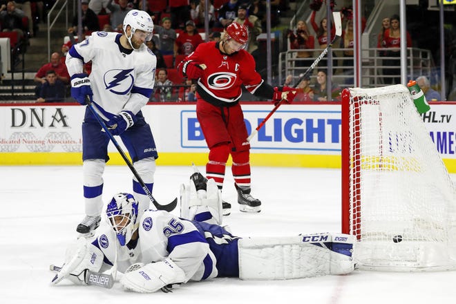 Tampa Bay Lightning goaltender Curtis McElhinney (35) lies on the ice after failing to stop the winning shot by Carolina Hurricanes' Jaccob Slavin in overtime in Raleigh, N.C., on Sunday. The Hurricanes won 4-3. [The Associated Press / Karl B DeBlaker]