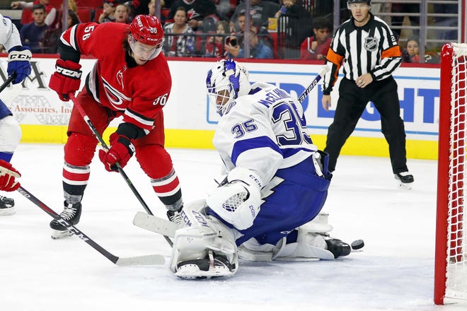 Carolina Hurricanes' Erik Haula (56) shoots the puck past Tampa Bay Lightning goaltender Curtis McElhinney for a goal during the second period of Sunday's game in Raleigh. The Hurricanes won their third straight overtime game. [Karl B DeBlaker/The Associated Press]