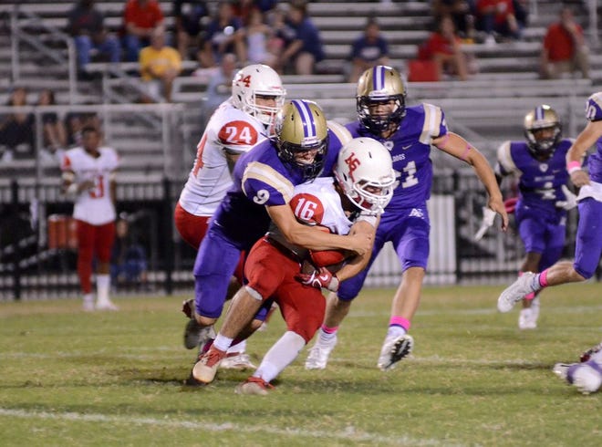 Ascension Catholic's Joel Landry wraps up a tackle of Philip Guarisco. Photo by Michael Tortorich.