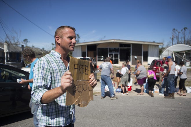 Justin Rascoe holds a sign advertising free food after Hurricane Michael on Oct. 12, 2018. He and his family felt they had more than enough food, so he decided to give away as much as they could. [JOSHUA BOUCHER/THE NEWS HERALD]