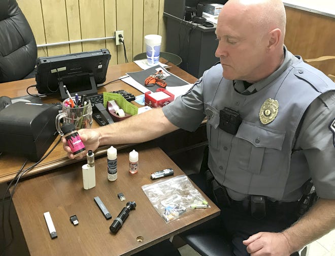 Bristol Virginia Police Officer Marlin Goff on Sept. 23, 2019, shows some of the vaping products he has confiscated from students at Virginia High School. [Tim Dotson/Bristol Herald Courier via AP]