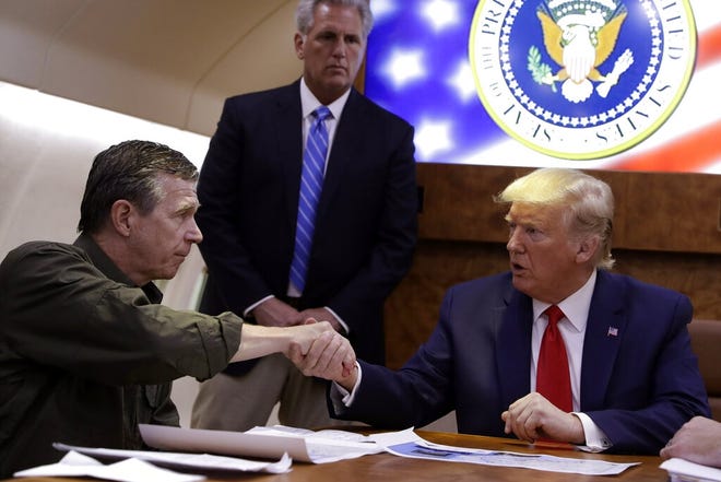 In this Sept. 9, 2019 file photo, President Donald Trump, right, participates in a briefing with North Carolina Gov. Roy Cooper about Hurricane Dorian at Marine Corps Air Station Cherry Point, in Havelock, N.C., aboard Air Force One. Cooper said Wednesday, Oct. 9 the federal government has denied individual assistance funds to help residents in four counties hit by Hurricane Dorian just days after approving other funds to help local governments repair infrastructure. [AP Photo/Evan Vucci, File]