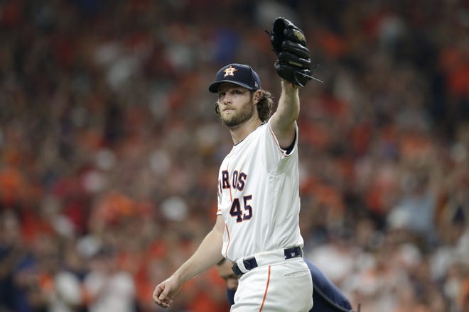 Houston Astros starting pitcher Gerrit Cole waves to fans as he leaves during the eighth inning of Game 2 of the baseball team's American League Division Series against the Tampa Bay Rays. [AP PHOTO/MICHAEL WYKE]