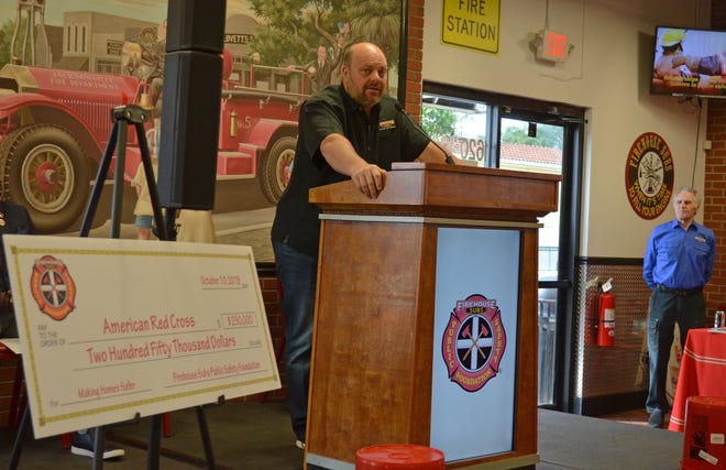 Jacksonville-based Firehouse Subs restaurant chain co-founder Robin Sorensen announces a $250,000 donation Thursday from the chain's Riverside restaurant as father and retired fire Capt. Rob Sorensen (rght) watches. [Dan Scanlan/Florida Times-Union]