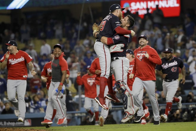 Washington Nationals pitcher Sean Doolittle, front left, and catcher Yan Gomes leap in celebration after the team's 7-3 win in Game 5 of the National League Division Series against the Los Angeles Dodgers on Wednesday. [MARCIO JOSE SANCHEZ/THE ASSOCIATED PRESS]