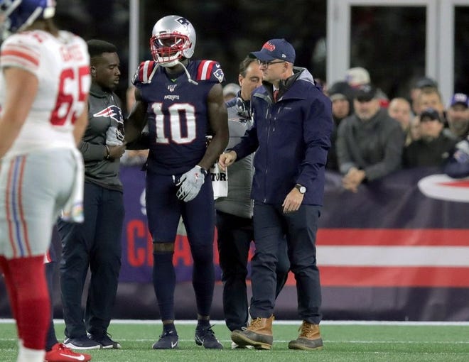 England Patriots wide receiver Josh Gordon is assisted from the field after an injury in the first half of an NFL football game against the New York Giants, Thursday, Oct. 10, 2019, in Foxborough, Mass.