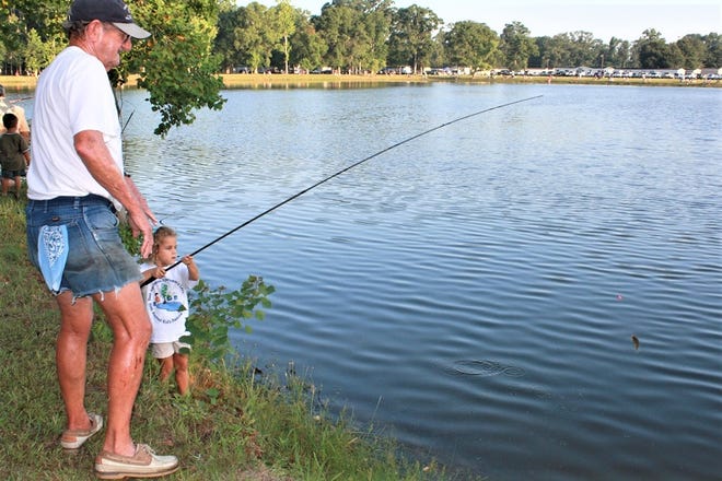 My granddaughter Isabella (Bella) pulling in a bream at an East Ascension Sportsman's League Kids Fishing Rodeo as Paw Paw Sonny looks on.