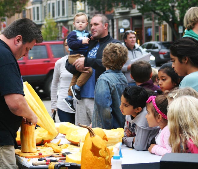 People watch as a professional pumpkin carver makes a creation. [Contributed]