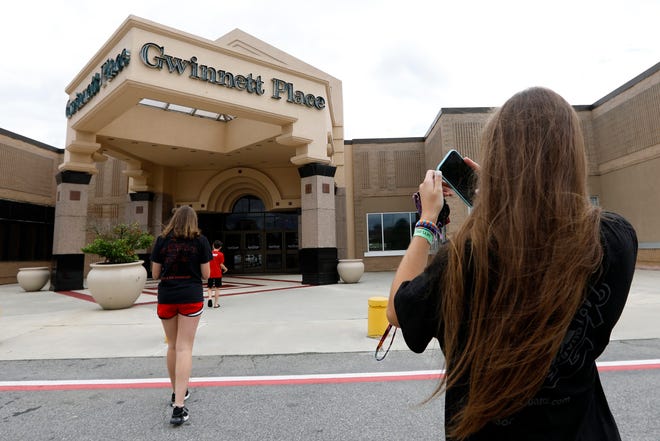 FILE - In this July 23, 2019 file photo, Brinley Rawson, a 17-year-old Stranger Things fan from Gwinnett County, snaps a photo of Gwinnett Place Mall in Duluth, Ga. The Georgia mall heavily featured in the latest season of Netflix's "Stranger Things" is going up for sale. Moonbeam Capital Partners is ready to sell its portion of the long-struggling Gwinnett Place Mall, which has been so empty that a body went unnoticed near the food court for about two weeks in 2017. (AP Photo/Andrea Smith, File)