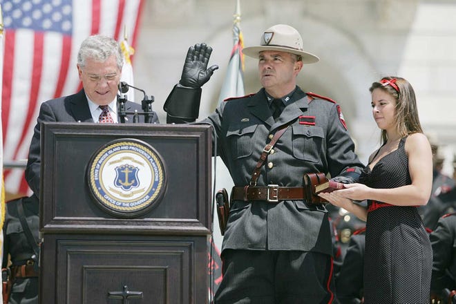 Then-Gov. Donald Carcieri swears in Col. Brendan Doherty as superintendent of the Rhode Island State Police in April 2007. Holding the Bible is Doherty's daughter, Shelby. [The Providence Journal, file / Glenn Osmundson]