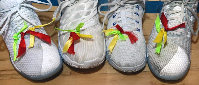 Three ribbons on the shoes of Paris senior volleyball players Paiton Forbis, from left, Faith Mainer, Ciara Boswell and Robyn Gossard signify their memory of Clint Mainer, Ashley Boswell and an eighth-grade classmate. [BRIAN D. SANDERFORD/TIMES RECORD]
