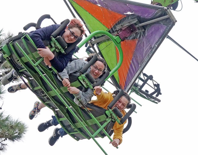 In the air are, from left, Matthew Desautell, 14; his mom, Karleen Desautell, from Lincoln; and Marie Desautell, Karleen's stepmom, visiting from Wisconsin, as the three generations take a ride Saturday on the Cliff Hanger at Autumnfest. [The Providence Journal / Sandor Bodo]