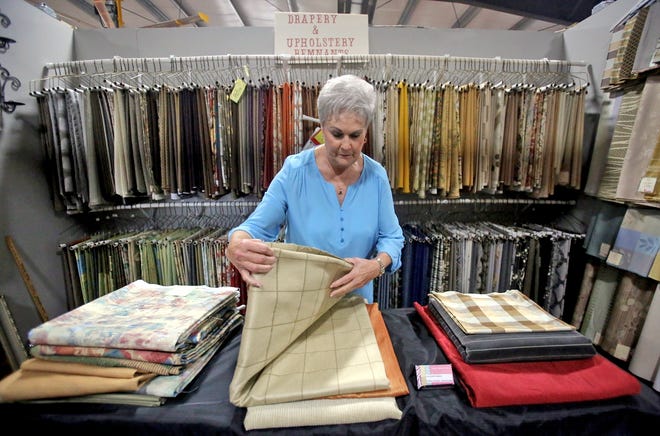 Gerry Latham arranges fabric at Back Road Pickers in Fallston. [Brittany Randolph/The Star]