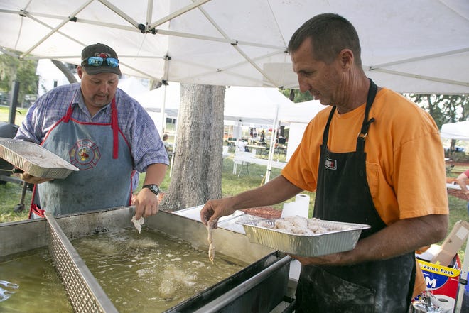 Swain Padgett and firefighter Jeff Moore drop frog legs and gator bites into the fryer at Beast Feast on Thursday. [Cindy Sharp/Correspondent]