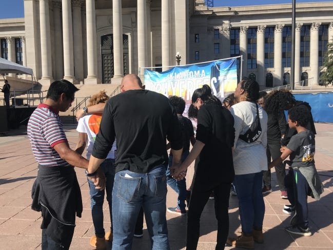 A group of people pray together at "Oklahoma Prayerfest" on Sunday on the south steps of the State Capitol. [Carla Hinton/The Oklahoman]