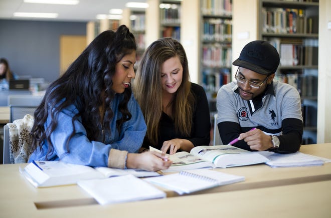 Three students from the University of Arkansas at Fort Smith read together in the library. [PHOTO COURTESY OF UAFS]