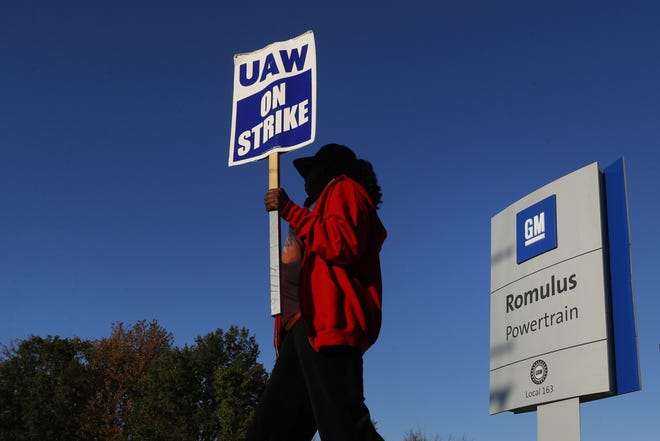 FILE - In this Oct. 9, 2019, file photo, Yolanda Jacobs, a United Auto Workers member, walks the picket line at the General Motors Romulus Powertrain plant in Romulus, Mich. With the strike by factory workers against General Motors in its 29th day on Monday, Oct. 14, there are signs that negotiators may be moving toward an agreement. (AP Photo/Paul Sancya, File)