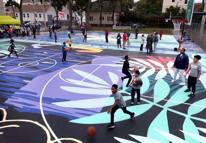 Neighborhood kids play on the colorful Omar Polanco courts unveiled Wednesday at Harriet & Sayles Park in Lower South Providence. The courts were painted by local Providence artist Jordan Seaberry and New York artist Joiri Minaya and dedicated to the memory of Omar Polanco, killed in a 2012 shooting at the park that remains unsolved.  [The Providence Journal / Kris Craig]