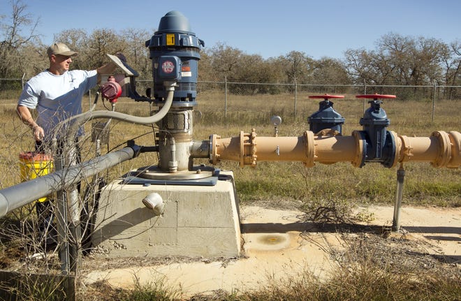 Allen Farley of Springs Hill Water, a contractor for Canyon Regional Water Authority, puts oil in a well pump at Wells Ranch near Leesville in 2012. The water authority has received grants from the Texas Water Development Board to serve rural communities. [JAY JANNER/AMERICAN-STATESMAN]