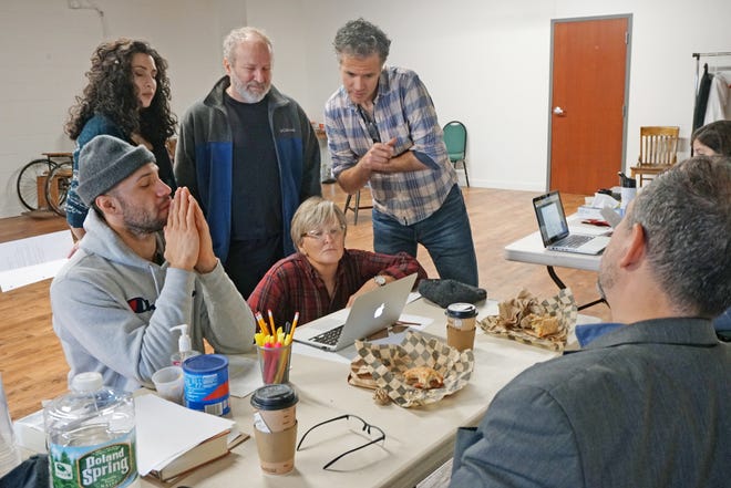 The cast of "JQA" gathers around a laptop to review some script changes in the production with playwright Aaron Posner, seated at bottom right. Standing, from left, are Helena Tafuri, Norman Beauregard and director Tony Estrella. Seated are Jonathan Higginbotham and Candice Brown. [The Providence Journal / Sandor Bodo]