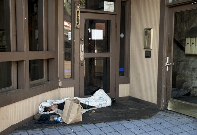A man sleeps in the doorway of an East Sixth Street bar Friday. New rules approved by the Austin City Council late Thursday will ban camping within 15 feet of any business or residential doorway. [JAY JANNER/AMERICAN-STATESMAN]
