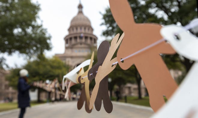 Volunteers in March hold a visual aid outside the Capitol showing how many Texans are uninsured. Each paper doll represented 1,000 uninsured Texans. [Stephen Spillman for Statesman]