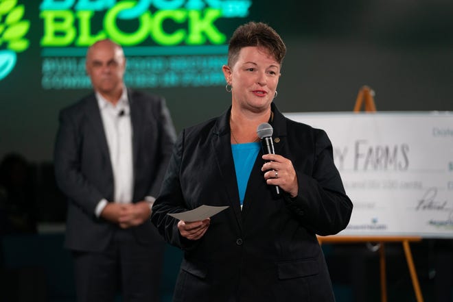 Angela TenBroeck, CEO of Foodery Farms in Jacksonville, talks about her idea to combat food insecurity by placing fresh-food vending machines in food-desert neighborhoods. She and her "farm-and-go" concept had just won Guidewell's Block by Block Food Insecurity Challenge in Orlando. Pat Geraghty, GuideWell president and CEO, listens in the background. [Provided by Guidewell]