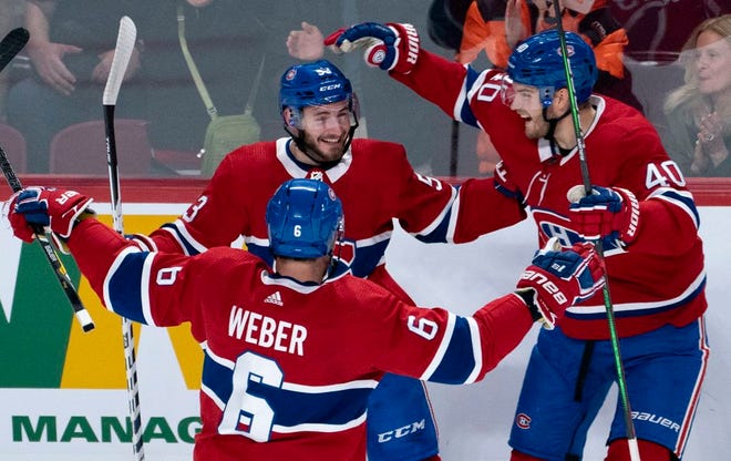 Montreal Canadiens' Victor Mete celebrates his goal against the Minnesota Wild with teammates Shea Weber, left, and Joel Armia, right, during first-period NHL hockey game action in Montreal on Thursday.