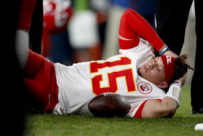 Kansas City Chiefs quarterback Patrick Mahomes lies on the field after being injured Thursday night against the Denver Broncos in Denver. Mahomes is expected to miss 4-6 weeks with a kneecap injury. [David Zalubowski/The Associated Press]