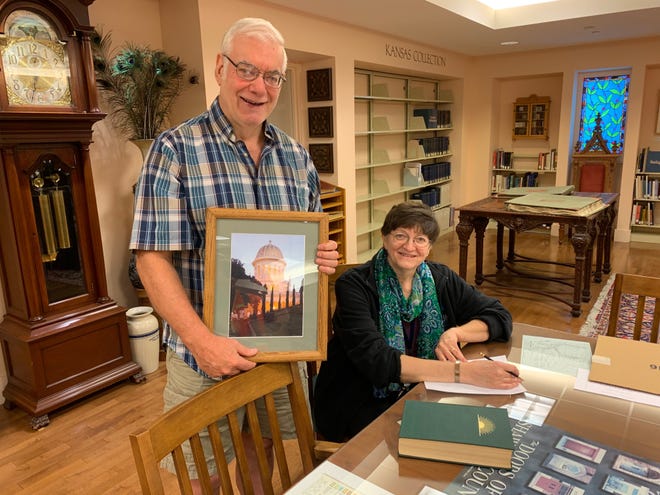 Duane Herrmann, holding a picture of the Baha'i World Center in Haifa, Israel, and Sherry Best, art collection curator at the Topeka and Shawnee County Public Library, discuss a special exhibit commemorating the 200th annivesary of the Birth of the Bab that will be on display in late October at the library, 1515 S.W. 10th Ave. [Phil Anderson/The Capital-Journal]