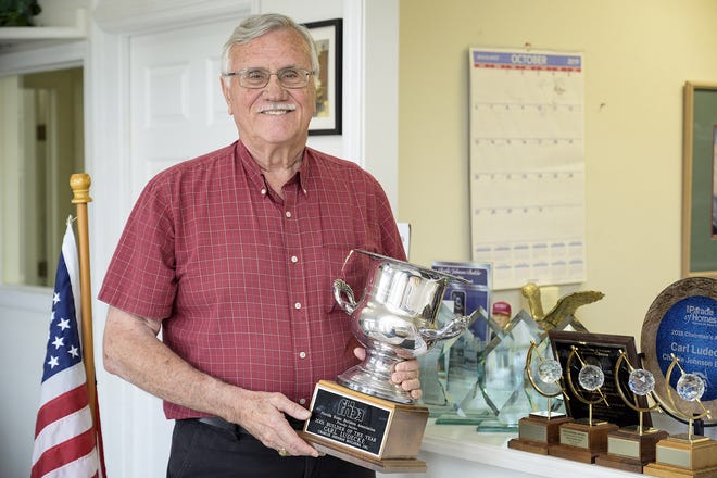 Vietnam War veteran Carl Ludecke holding his award for Builder of the Year. [Cindy Sharp/Correspondent]