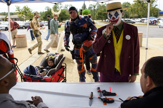 David Mireles, dressed as The Joker, has his cosplay weapons checked by Cumberland County Sheriffs Office deputies before entering the 2019 Fayetteville Comic Con on Oct. 19, 2019, at the Crown Expo. [Melissa Sue Gerrits/The Fayetteville Observer]
