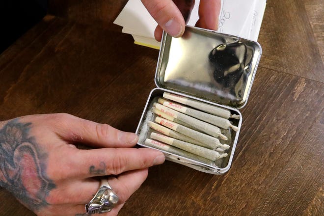 In this Wednesday, Oct. 9, 2019 photo, a clerk packs pre-rolled marijuana joints for a customer at the Medicinal Cannabis Dispensary, an unlicensed marijuana shop, in Vancouver, B.C. Around the province, authorities have visited 165 illegal dispensaries in the past year and warned them to get licensed or shut down. But despite a few raids, the government has been reluctant to close them all before more licensed shops open. (AP Photo/Elaine Thompson)
