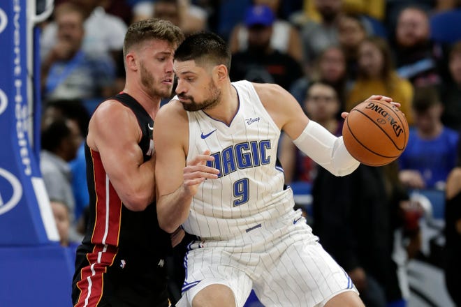 Orlando Magic's Nikola Vucevic (9) makes a move to the basket against Miami Heat's Meyers Leonard last week in Orlando. [ JOHN RAOUX/THE ASSOCIATED PRESS ]