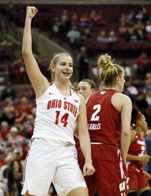 Ohio State Buckeyes forward Dorka Juhasz (14) raises her fist to celebrate a field goal and foul call by guard Carly Santoro (10) behind Wisconsin Badgers guard Kelly Karlis (2) during the third quarter of the NCAA women's basketball game at Value City Arena on Feb. 17, 2019. Ohio State won 70-68. [Adam Cairns/Dispatch]