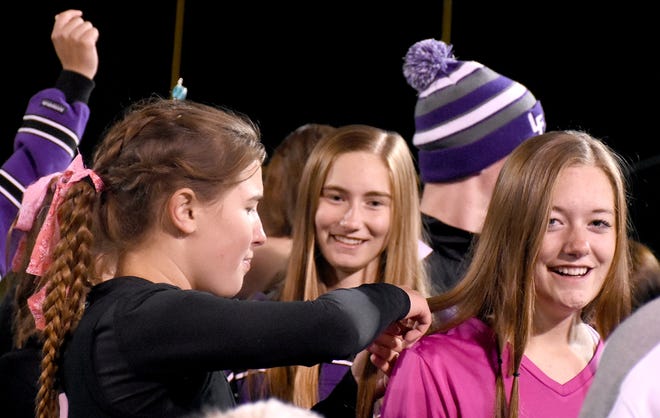 Senior goalie Hannah Young (right) reacts as Little Falls field hockey teammate Halle Feane (left) cuts a lock of her hair with her younger sister, Sammie Young, looking on during an end-of-season postgame ritual Saturday. 

[Jon Rathbun / Times Telegram]