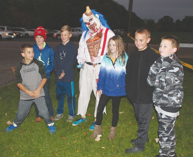 A macabre clown poses for photos with kids standing in line at a previous Bakersville Halloween event.