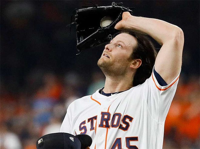 Houston Astros starting pitcher Gerrit Cole wipes his fave after giving up a two-run double to Washington Nationals' Juan Soto during the fifth inning of Game 1 of the baseball World Series Tuesday night in Houston. [Matt Slocum/The Associated Press]