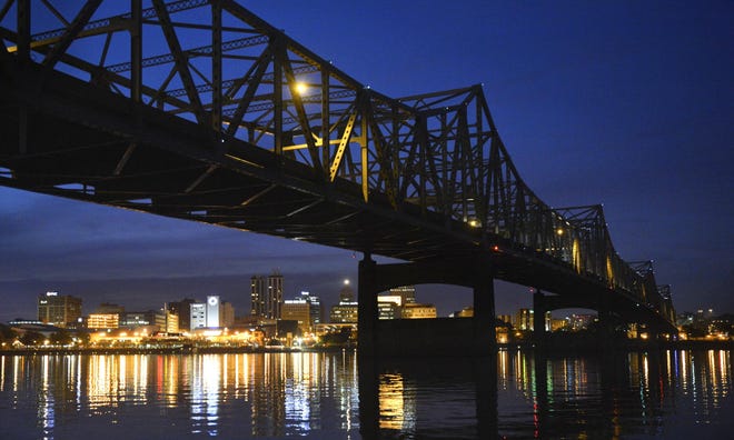 The lights of the city of Peoria reflect off the Illinois River under the expanse of the darkened Murray Baker Bridge. The new Illinois Department of Transportation five-year work plan includes funds for adding lights to the bridge when the deck on it is replaced next year. [RON JOHNSON/JOURNAL STAR FILE PHOTO]